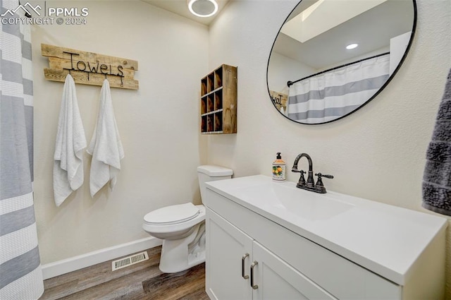 bathroom featuring a shower with curtain, hardwood / wood-style flooring, vanity, and toilet