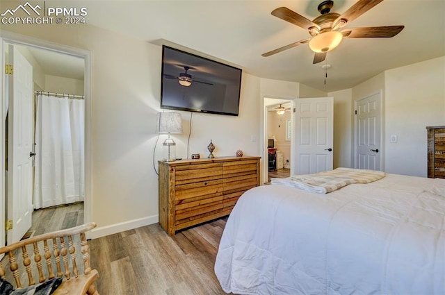 bedroom with ceiling fan, ensuite bathroom, and hardwood / wood-style floors