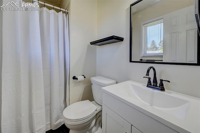 bathroom with walk in shower, vanity, and toilet