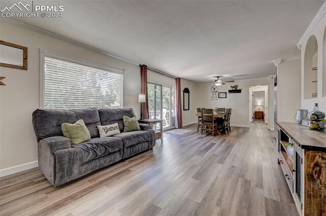 living room featuring light hardwood / wood-style flooring, ceiling fan, and crown molding