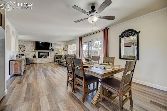 dining room featuring crown molding, a fireplace, and ceiling fan