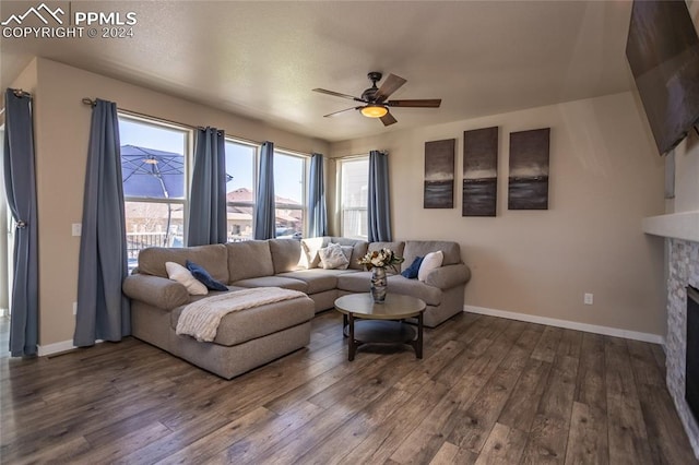 living room featuring wood-type flooring, ceiling fan, and a fireplace