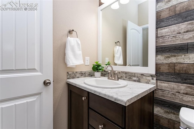 bathroom with vanity, backsplash, and toilet