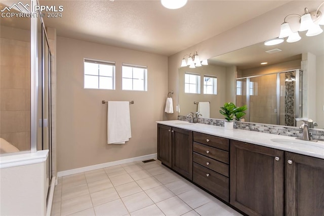 bathroom with tile patterned floors, an enclosed shower, and vanity