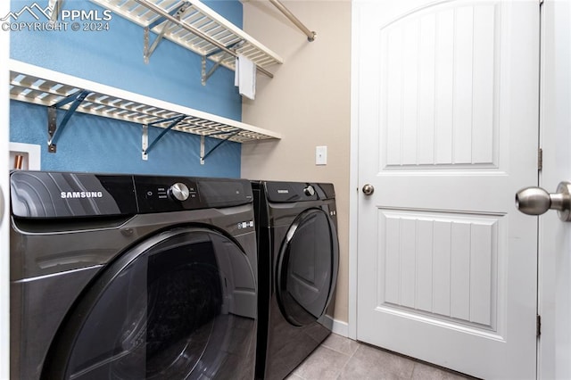 laundry room with washer and clothes dryer and light tile patterned flooring