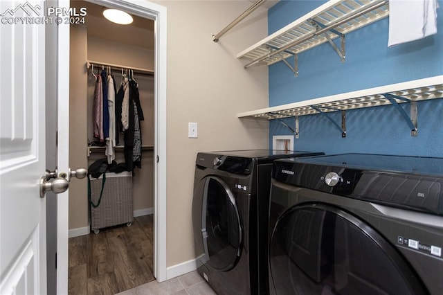 clothes washing area with wood-type flooring and washer and dryer