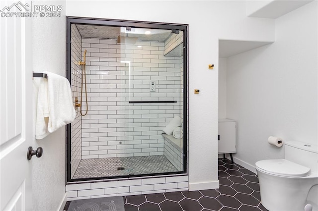 bathroom with toilet, tile patterned floors, and a shower with shower door