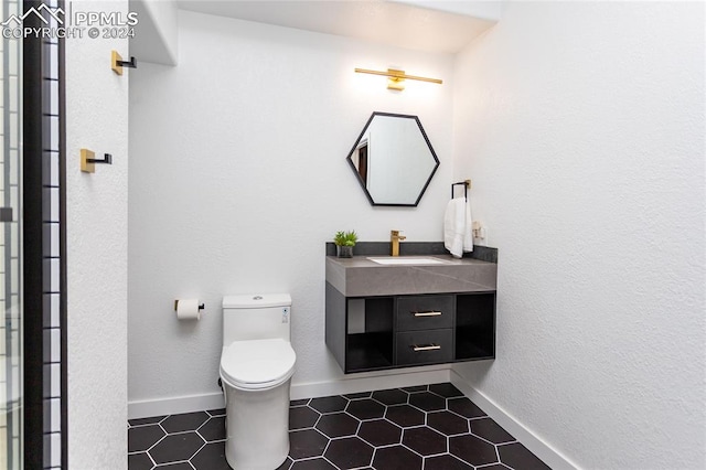 bathroom featuring tile patterned flooring, vanity, and toilet