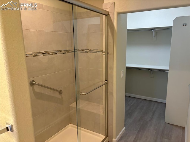 bathroom featuring a shower with door and hardwood / wood-style flooring