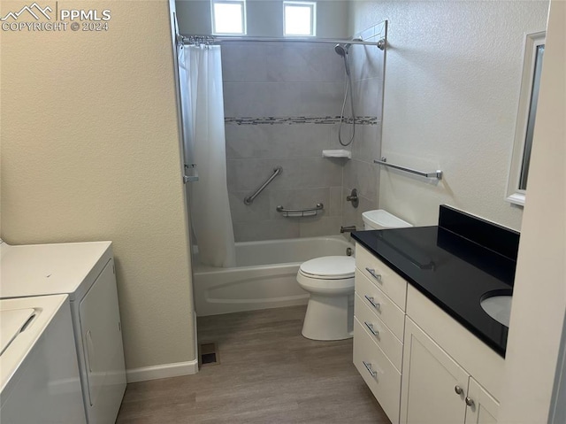 full bathroom with vanity, shower / tub combo, washer and dryer, hardwood / wood-style flooring, and toilet