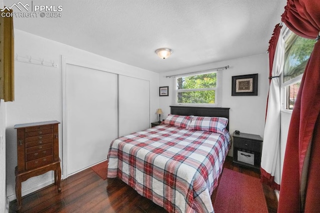 bedroom with dark hardwood / wood-style flooring and a closet