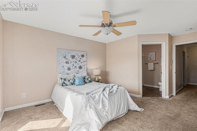 carpeted bedroom with ensuite bath and ceiling fan