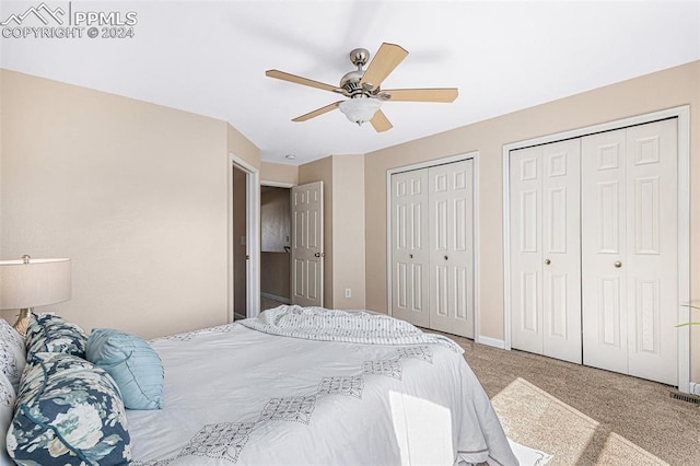 carpeted bedroom with multiple closets and ceiling fan