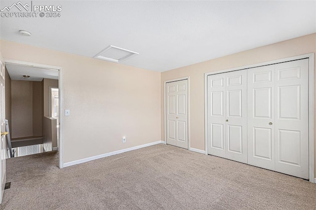 unfurnished bedroom featuring carpet and multiple closets