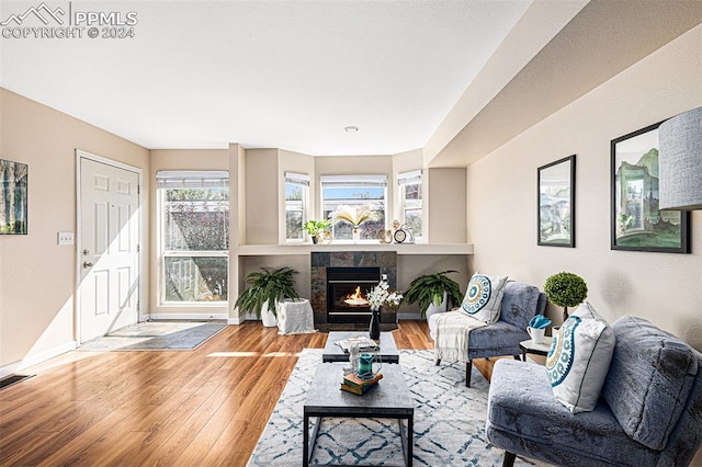 living room with wood-type flooring and a tile fireplace