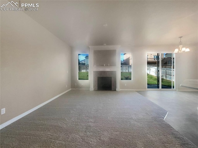 unfurnished living room with a fireplace and a chandelier