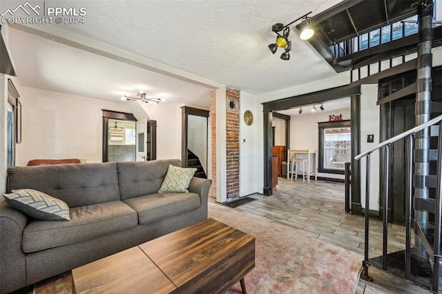 living room with wood-type flooring, a textured ceiling, and rail lighting