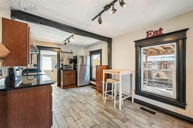 kitchen featuring stainless steel appliances, light wood-type flooring, and a healthy amount of sunlight