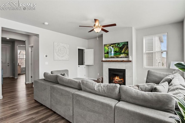 living room with a tiled fireplace, ceiling fan, and dark hardwood / wood-style floors