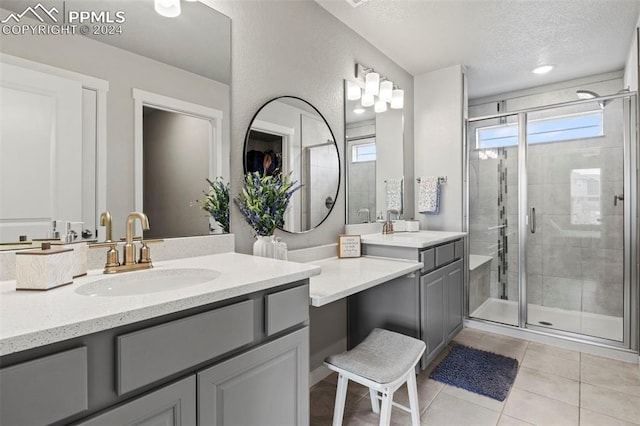 bathroom with a textured ceiling, tile patterned flooring, vanity, and an enclosed shower