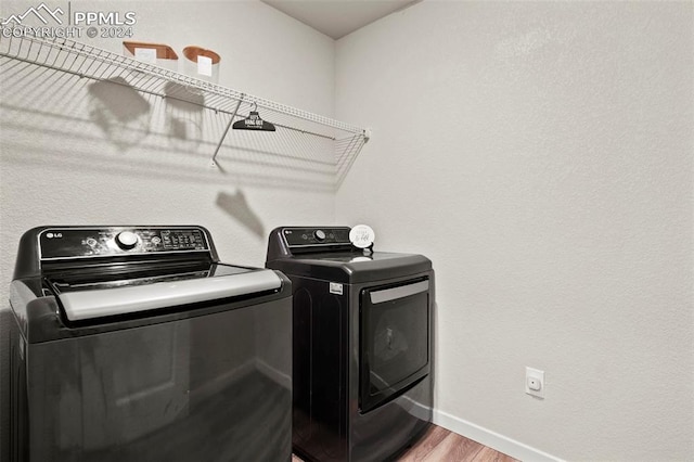 laundry area featuring hardwood / wood-style floors and separate washer and dryer