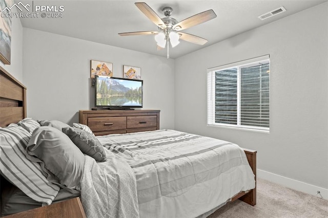 carpeted bedroom featuring multiple windows and ceiling fan