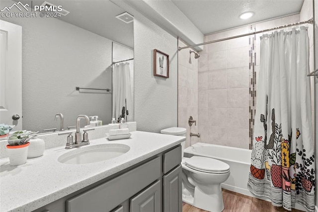 full bathroom featuring hardwood / wood-style floors, vanity, toilet, and shower / bath combo with shower curtain