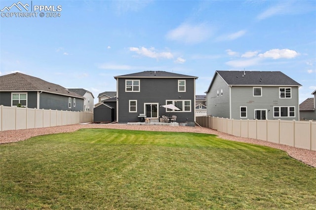 back of house featuring a lawn and a patio