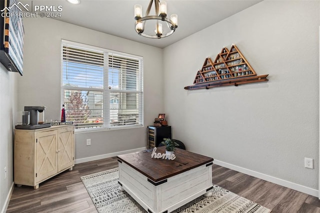 sitting room with a chandelier and dark wood-type flooring