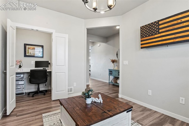 home office with an inviting chandelier and dark hardwood / wood-style floors