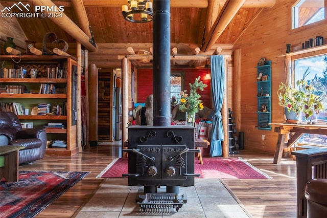 interior space with vaulted ceiling with beams, hardwood / wood-style floors, and a wood stove