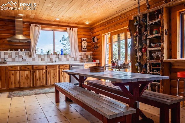 dining area featuring wood ceiling, rustic walls, light tile patterned floors, and sink