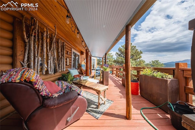 wooden deck featuring a mountain view and an outdoor living space