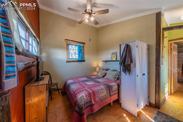 bedroom with ceiling fan, light wood-type flooring, and ornamental molding