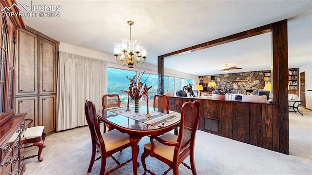 carpeted dining area featuring ceiling fan with notable chandelier