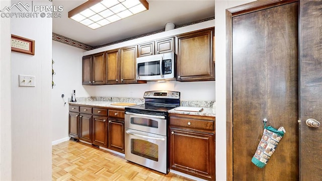 kitchen featuring appliances with stainless steel finishes and light parquet flooring