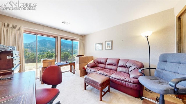 living room featuring light carpet and a mountain view