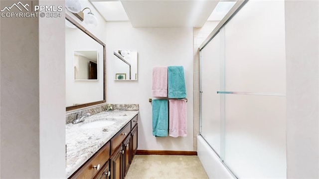 bathroom featuring vanity and combined bath / shower with glass door