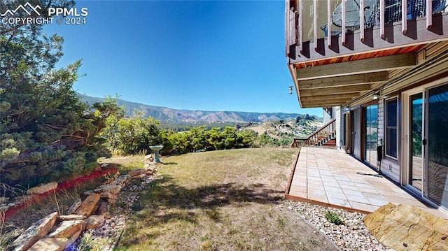 view of yard featuring a mountain view and a patio area