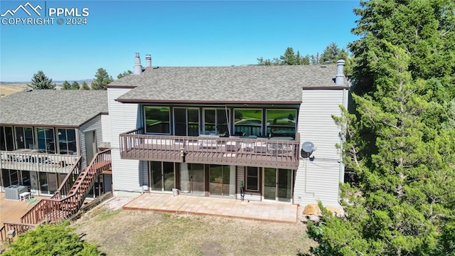 back of house featuring a wooden deck, a sunroom, and a patio