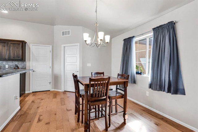 dining space featuring light hardwood / wood-style floors and a chandelier