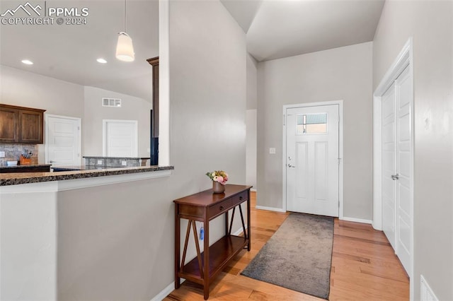 entrance foyer with lofted ceiling and light hardwood / wood-style floors