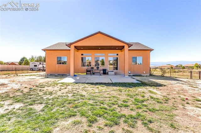 rear view of house featuring a patio and a lawn