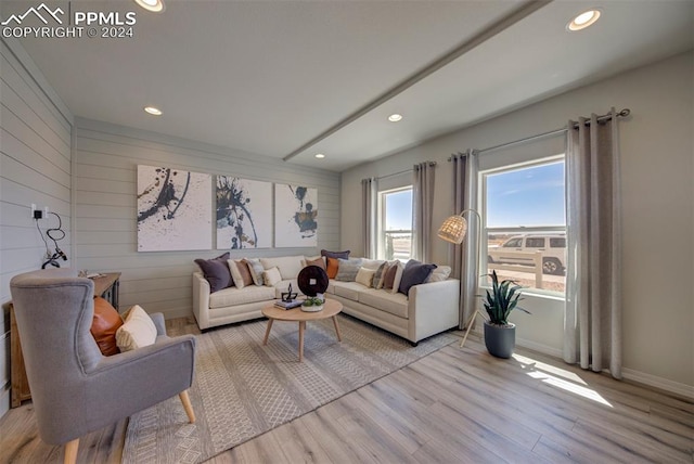 living room featuring wooden walls and light hardwood / wood-style flooring