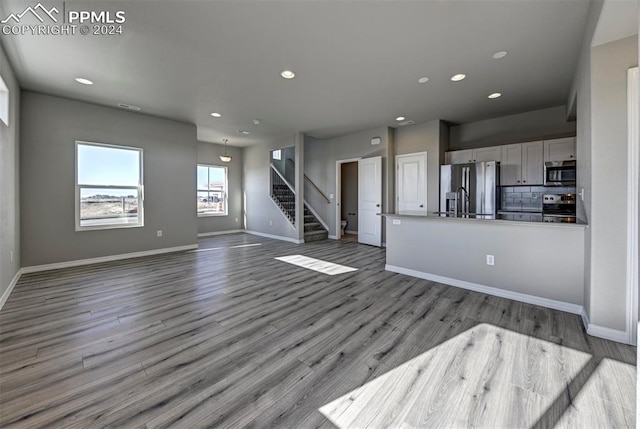 unfurnished living room featuring light hardwood / wood-style flooring and sink