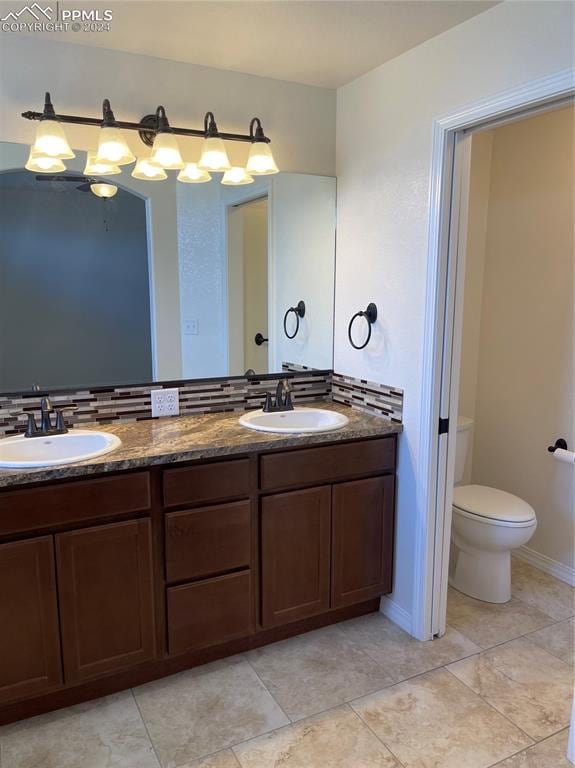 bathroom with vanity, tile patterned flooring, and toilet