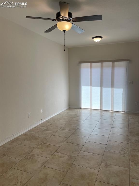 tiled spare room featuring ceiling fan