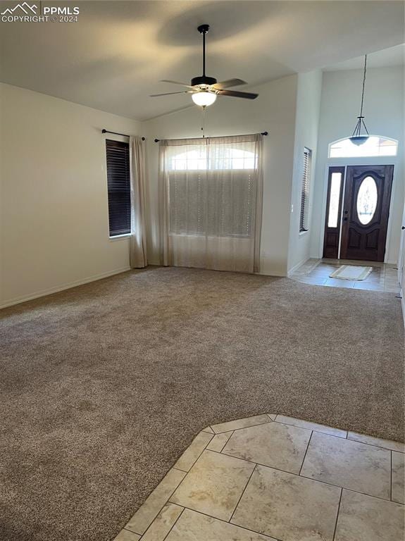 unfurnished living room featuring ceiling fan and light colored carpet