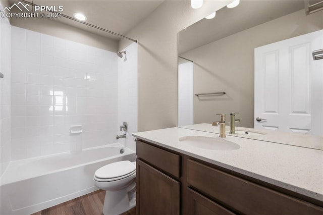 full bathroom with vanity, bathing tub / shower combination, hardwood / wood-style floors, and toilet