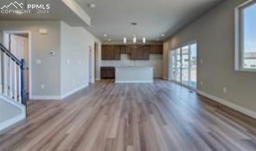 unfurnished living room featuring a wealth of natural light and hardwood / wood-style floors